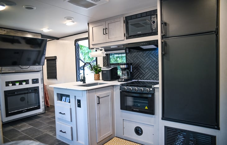 Cook with a view! Our farmhouse sink and large windows bring in natural light and scenic views, making meal prep in this stylish kitchen a true pleasure.