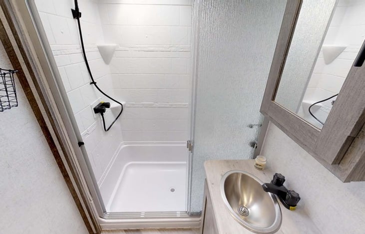 Large shower with glass sliding door, tall enough for someone 6'5