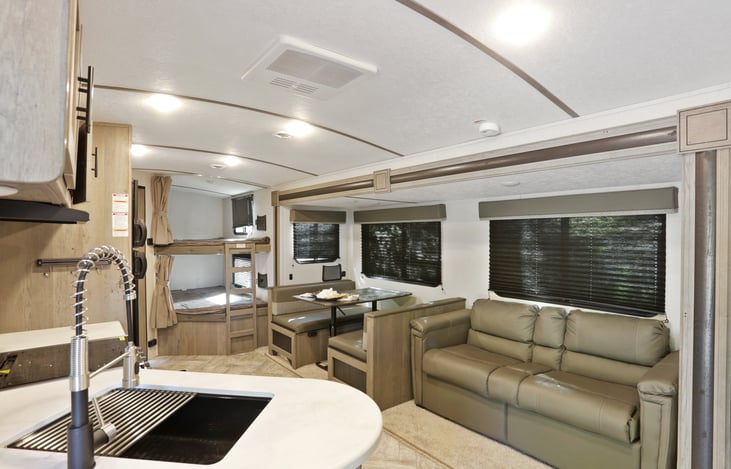 Full size bunk beds. Dinette and sofa pull out into sleeping area. Farmhouse sink in sight.