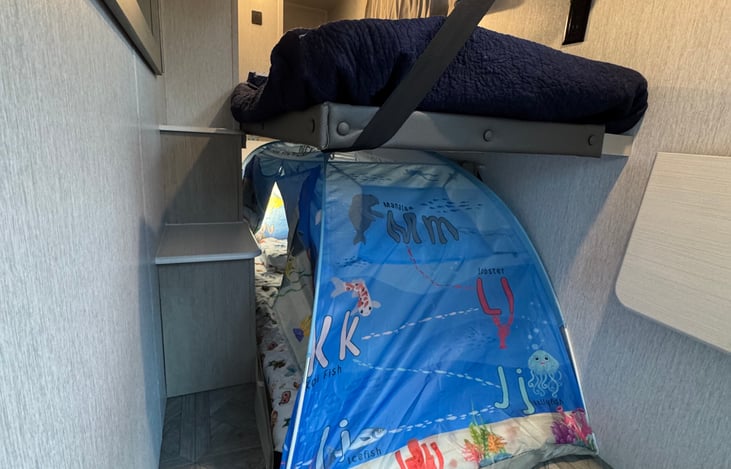 Bunkbeds in slide out, toddler tent can collapse. The slide out has outlets, USBs and a small activity table.