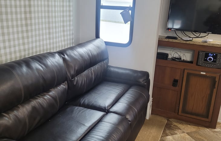 fold out couch, large TV with bluetooth entertainment center including dvd player and outdoor speakers