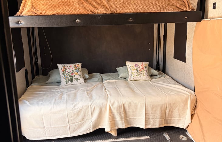 Bunk beds. The bottom beds can have a thin mattress over them to make one big bed.