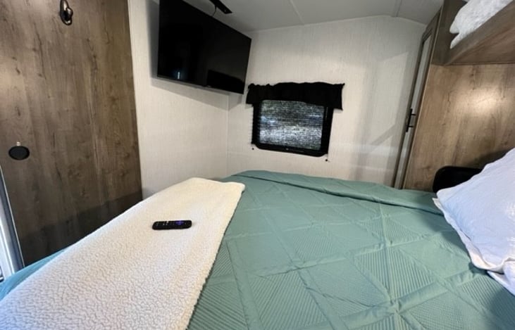 Primary with queen bedding, two closets with interior lighting and overhead and underneath storage.