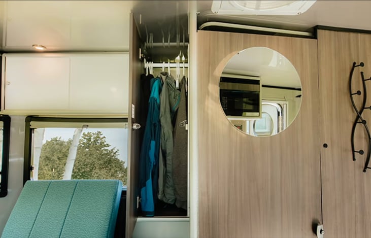 Closet with clothes hanger rod. Mirror on outside of bathroom door. Pegs for hanging things up too.