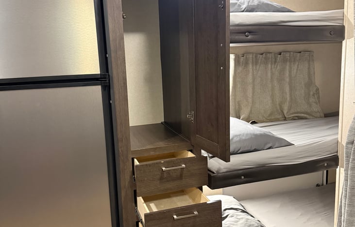 Large storage compartment beside trip bunk with three drawers underneath for additional storage.