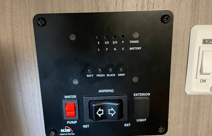 Control center for the fresh, black, and grey tanks. Also water pumper, and heater switch.