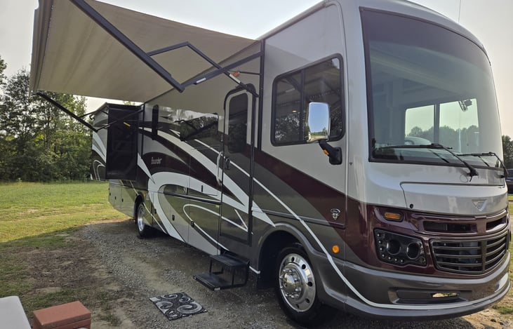 View of passenger's side with awning extended and master bedroom slide out extended.