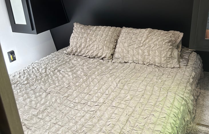 Queen size bed in bedroom with door for privacy.