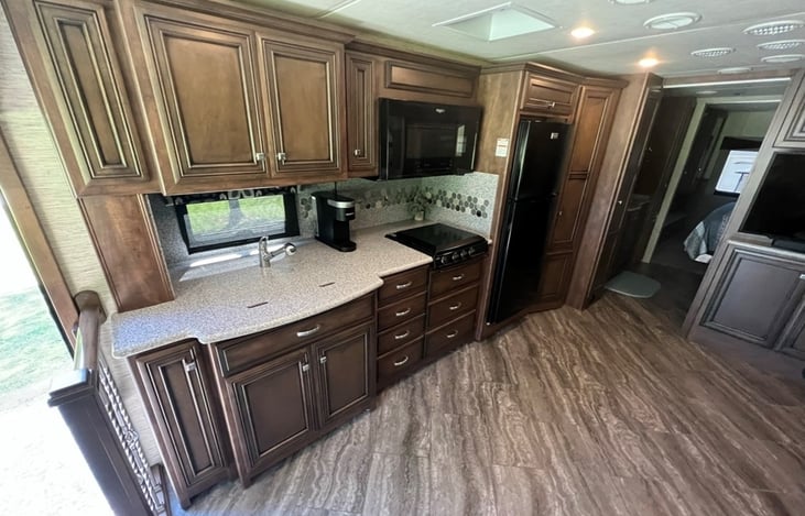 Kitchen with 2 stainless steel sinks, 3 gas burner stove, microwave/convection oven, refrigerator/freezer and 2 pantries.