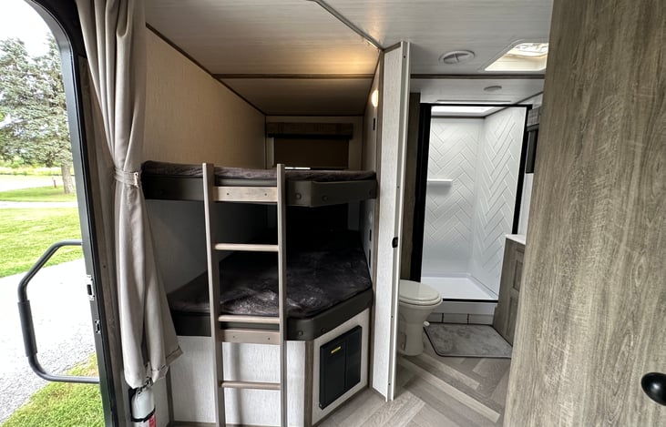 BATHROOM IS LOCATED AT THE END OF RV. IF TRAVELING AND NEED TO USE THE BATHROOM IT IS EASILY ACCESSIBLE EVEN WITH THE SLIDE OUT IN.