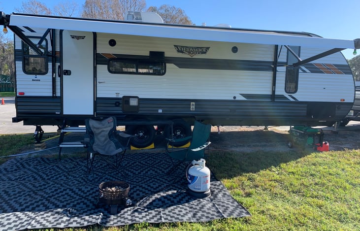 2 outdoor camping chairs, table, and ground covering rug are included.