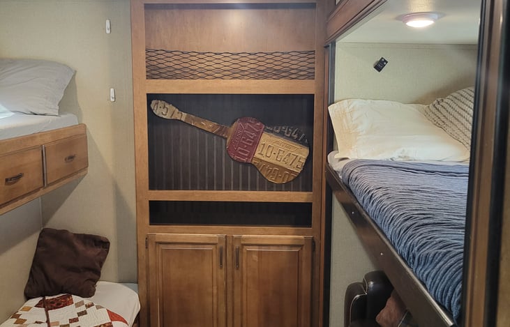 bunk room with 3 bunk beds and queen size pull out couch, closet and ample drawer storage