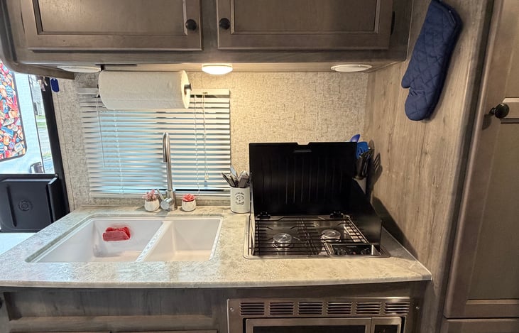 2 burner stove, double sink, microwave, with 5-cup coffee maker and filters, and a toaster in pantry.  Pantry staple items such as oil and basic spices included, as well as plates, bowls, and cups.