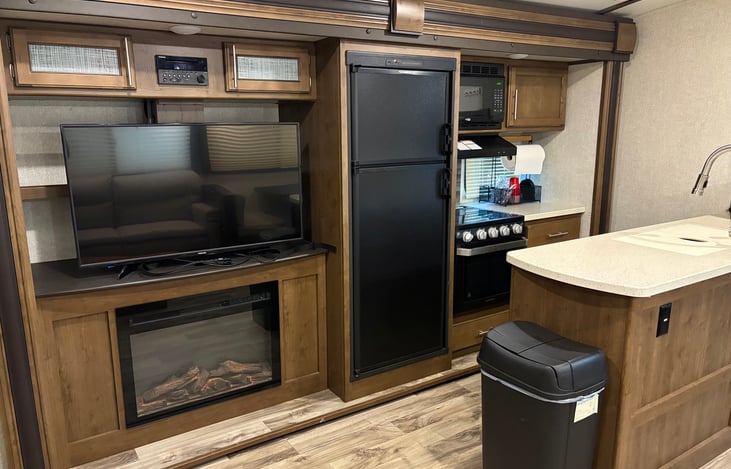 Living room TV, fireplace and kitchen