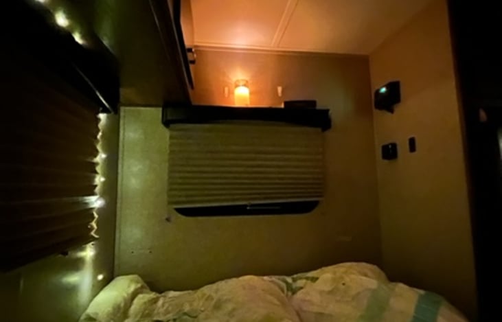 Cozy interior at night time with fake candle light, bed all set up