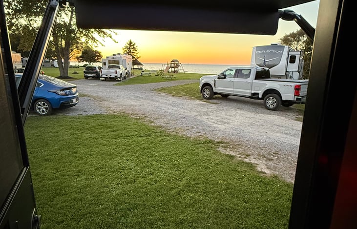 View of sunset over Lake Ontario from camper door. Daisy Barn Campground is a MUST STAY if you’re taking a trip to Niagara Falls.