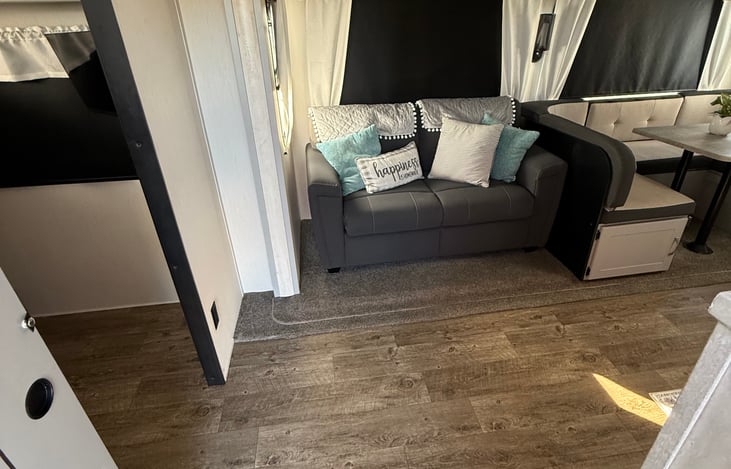 Sliding door to bunkhouse on the left.  This cozy couch opens up to sleep 1-2 additional people. These bunches couch is directly across from a large TV.