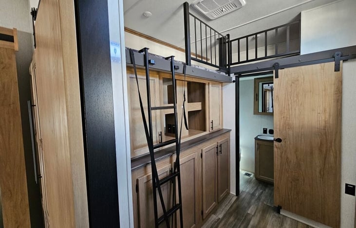 Bedroom 2/Bunk area. Includes sofa with makes full -size bed, bunk bed above couch, 2 more bunk in nest above storage area