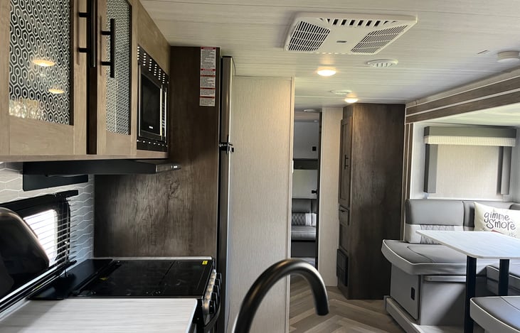 view to back of camper to second bedroom that has a desk, 2 small bunkbeds, small storage.
