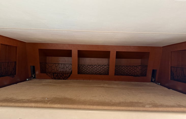 Drop down bed above drivers and passenger seat. Kids favorite nickname the “ birds nest “ with plenty of storage.