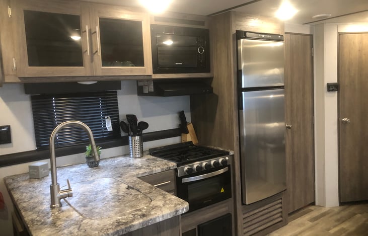 Spacious kitchen with moderate countertop space.  Refrigerator/freezer, 3-burner stove top, oven and microwave