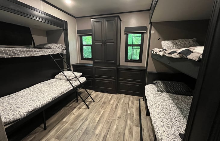 Bunk House sleeps 5. Bed on bottom right turns into a dinette for activities. There are 6 deep drawers for clothes as well as a closet with hangers. Three bunks have personal windows.