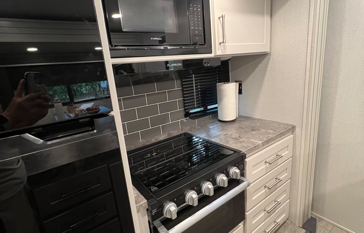 Kitchen with gas stove, microwave, full size fridge/ freezer combo