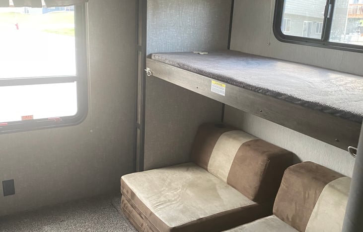 Upper bunk and couch seats unfold into a bed area. Or am air mattress fits in this area if cushions are put on top of bunk