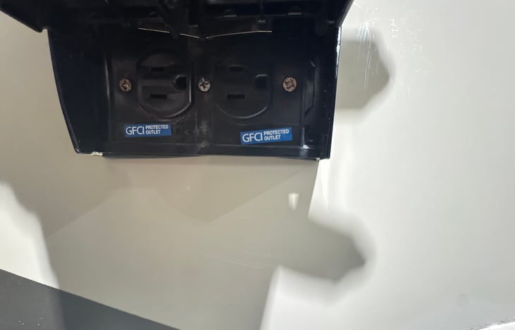 Two 3-prong electrical outlets on right side of RV where awning and main door are located.