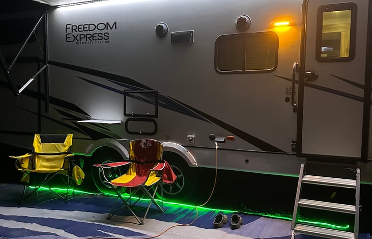 Enjoy sitting outside at night with lights, chairs and an outdoor rug.