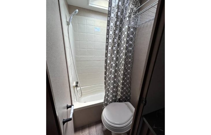 Bathroom in rear features bathtub, toilet and separate powder area.