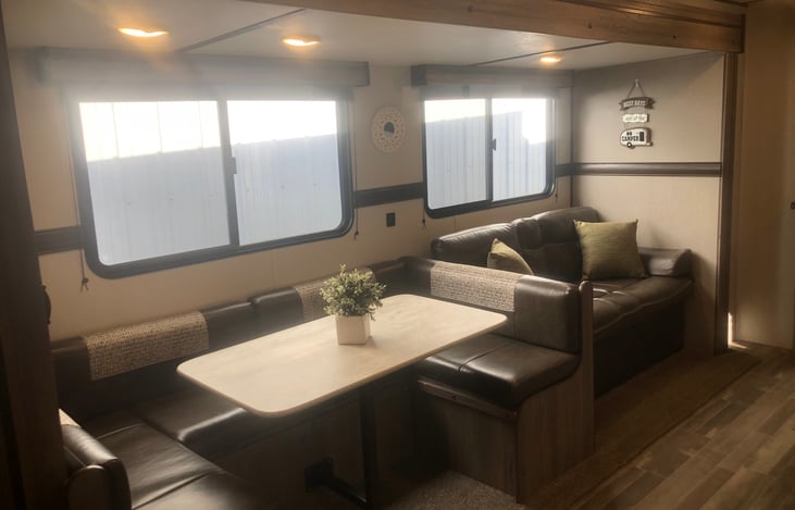 View from bathroom looking into the living area.  Horseshoe dinette, jacknife couch that convderts into a double bed