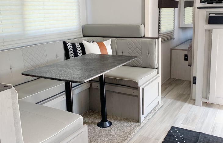 Dining area is a place where guests can relax and others are cooking in the kitchen area.