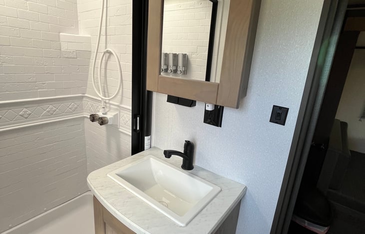Bathroom sink and cabinet for storage.