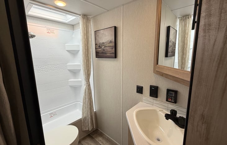 Large bathroom with a extra tall shower.