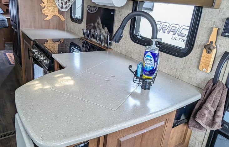 Additional counter space over the sink and cleaning supplies included