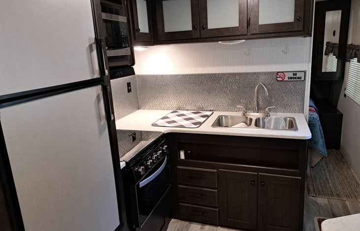 Full Kitchen, filled with dishes, pots, pans, Coffee maker, etc.