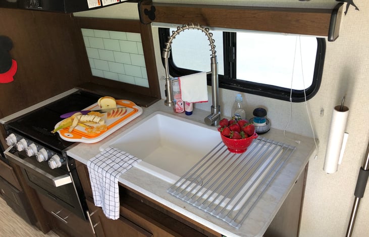 The stove has an attached glass cover to add counter space when not in use.