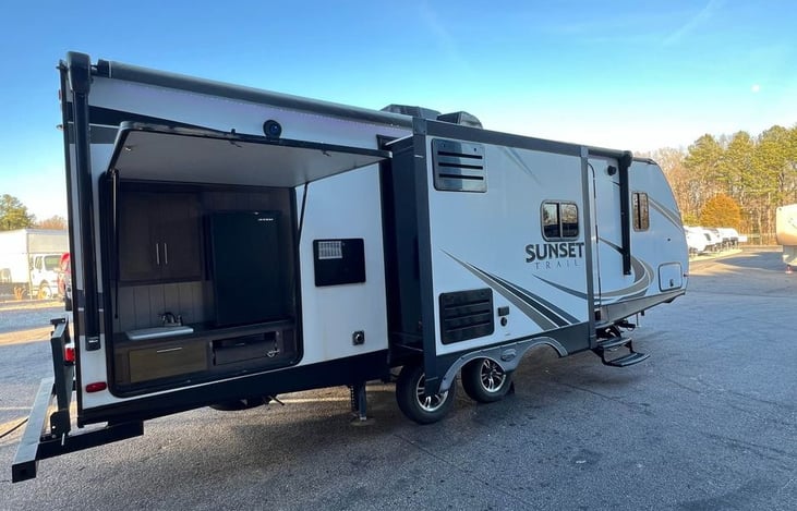 Outdoor kitchen with fridge, sink, and cooktop — ideal for tailgates, grilling, or keeping the mess outside. Dual slide-outs provide tons of interior space too!