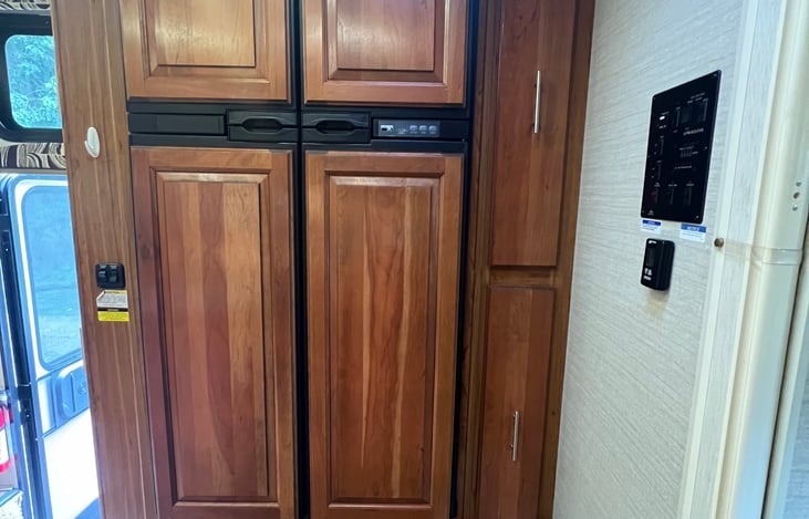 Full refrigerator and freezer with large pull out pantry next to refrigerator