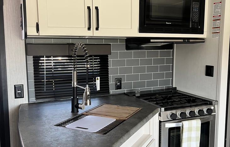 Kitchen with microwave and stove and large sink.
Very modern!