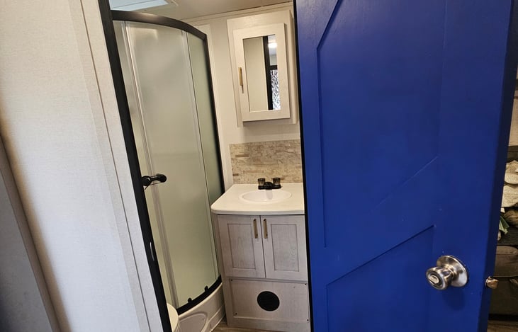 Step inside this bright bathroom through the charming blue door — a refreshing touch of style