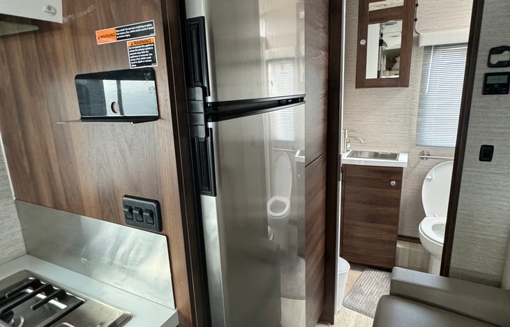 Full size refrigerator and image of bathroom doorway