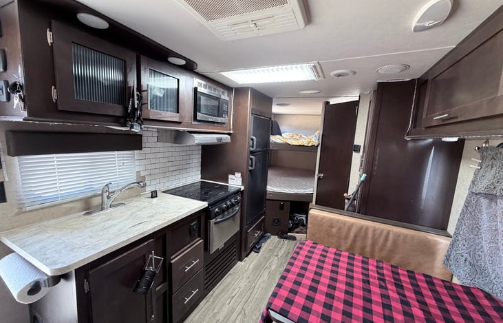 Looking back at kitchen, dinette, double bunk and bath