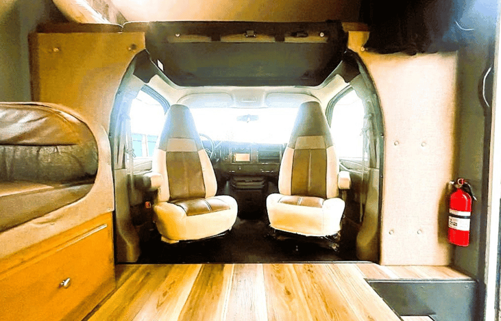 Clean driver cabin and seating area inside our Class C RV rental — road-ready comfort with unlimited mileage.