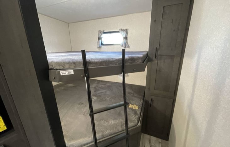 Double queen size mattress bunkhouse with fixed ladder.