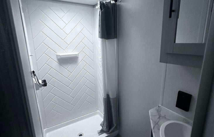 All you really need.  Small shower, toilet, sink and a vanity with storage!