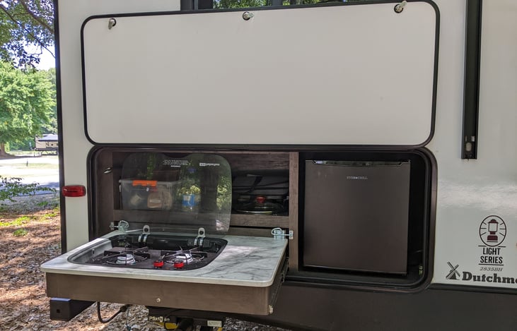 Outdoor kitchen with a two-burners gas stove and a small refrigerator. The gas grill(not visible) can also be connected.