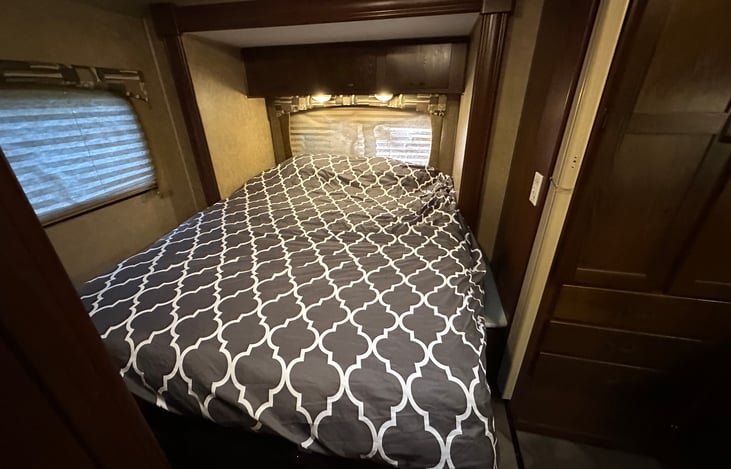 Slide out queen bed with two inch memory foam mattress topper, water proof mattress cover and luxury linens.