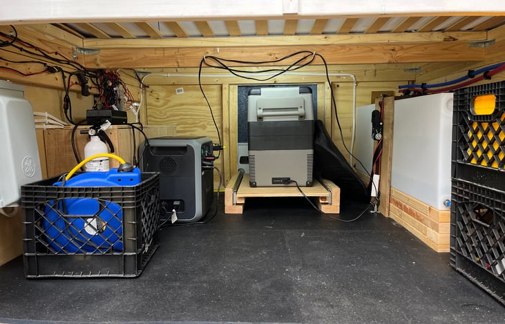 Utility garage under the fixed bed. 45 gallon water tank, 110V AC shore connection, Bluetti portable power station w/ battery bank and inverter, and plenty of space left for your outdoor gear.
